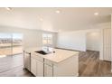 Modern kitchen with white cabinets, stainless steel appliances, and a large island, with an open concept layout at 3911 N Shawnee St, Aurora, CO 80019