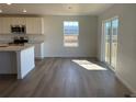 Living room features hardwood floors, stainless steel appliances, and sliding glass doors to the backyard at 3911 N Shawnee St, Aurora, CO 80019