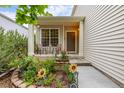 Inviting front porch with seating area surrounded by beautiful flower garden at 2905 S Deframe Way, Lakewood, CO 80228