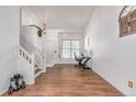 Bright living room with hardwood floors, staircase, and a comfortable workspace at 2905 S Deframe Way, Lakewood, CO 80228