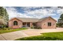 Attractive brick home with a welcoming front porch and mature landscaping at 1660 Old Antlers Way, Monument, CO 80132
