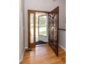 Inviting foyer with a wood door, side panel window, and hardwood flooring at 1660 Old Antlers Way, Monument, CO 80132