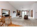 Spacious living room featuring a brick fireplace, vaulted ceilings, and sliding glass doors to a deck at 1660 Old Antlers Way, Monument, CO 80132