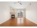 Spacious living room with hardwood floors, fireplace and sliding doors to balcony with natural light at 7440 S Blackhawk St # 7-303, Englewood, CO 80112