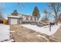 Front view of a ranch home with a driveway and snow-covered yard at 16193 E Dickenson Pl, Aurora, CO 80013