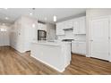Stylish kitchen with white cabinets, stainless steel appliances, and hardwood floors at 27639 E 7Th Ln, Aurora, CO 80018