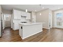 Bright, modern kitchen features white cabinets, stainless steel appliances, and an island at 27639 E 7Th Ln, Aurora, CO 80018