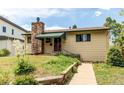 Inviting home with a stone chimney, green awning, and landscaped walkway at 1275 Niagara St, Denver, CO 80220