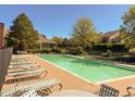 Community pool surrounded by lounge chairs and lush landscaping at 4231 S Fairplay Cir # A, Aurora, CO 80014