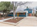 Bright home featuring blue siding, orange shutters and garage door, concrete driveway, and rock landscaping at 1120 Hartford Dr, Boulder, CO 80305