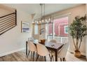 Cozy dining area with modern lighting, seating for six, and sliding doors to the outdoor patio at 9769 E 62Nd Dr, Denver, CO 80238