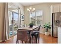 Sunny dining area with wood floors, a modern light fixture, and sliding glass doors to the patio at 22965 E Bailey Cir, Aurora, CO 80016