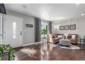 Bright living room with hardwood floors, a cozy sofa, and a large window that allows for plenty of natural light at 3541 E 118Th Ave, Thornton, CO 80233