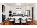 Modern kitchen with sleek cabinetry, quartz island, designer lighting, and dining space for entertaining at 8806 E 35Th Ave, Denver, CO 80238