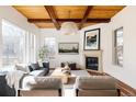 Bright living room featuring a fireplace, wood ceiling beams, and large windows for a welcoming atmosphere at 8806 E 35Th Ave, Denver, CO 80238