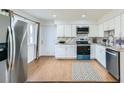 Bright kitchen with stainless steel appliances, white cabinets, and hardwood floors at 8471 Rainbow Ave, Denver, CO 80229