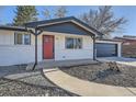 Updated ranch-style home with red front door, black trim, and low maintenance landscaping at 8340 W 70Th Ave, Arvada, CO 80004
