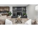 Cozy living room with a painted brick fireplace, modern decor, and open to kitchen at 7882 S Independence Way, Littleton, CO 80128