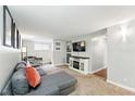 Cozy living room featuring a sectional sofa, TV, fireplace, and desk area for a comfortable and functional space at 1155 N Ash St # 102, Denver, CO 80220