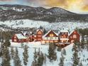The exterior of a mountain home is lit up and backdropped by a vivid sunset at 300 Gold Hill Rd, Breckenridge, CO 80424