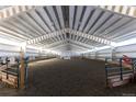Spacious indoor horse riding arena with sand floor and white metal siding and roof at 300 Gold Hill Rd, Breckenridge, CO 80424