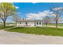 Charming white home exterior with front patio seating area and well-maintained lawn at 19810 County Road 1, Berthoud, CO 80513