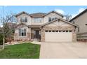 Inviting two-story home showcases stone accents, neutral siding, manicured lawn and an attached two car garage at 24355 E Briarwood Ave, Aurora, CO 80016