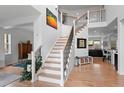 Bright foyer features wood floors, staircase with iron railing, soaring ceilings, and decorative lighting at 24355 E Briarwood Ave, Aurora, CO 80016