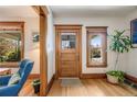 Inviting entryway featuring hardwood floors, a wooden front door with glass, and natural light from a side window at 3361 W 29Th Ave, Denver, CO 80211