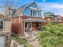 Two-story brick home featuring a cozy front porch, well-kept landscaping, and a blue and brick exterior at 3361 W 29Th Ave, Denver, CO 80211