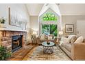 Spacious living room features vaulted ceilings, large arched window, brick fireplace, and hardwood floors at 156 S Lindsey St, Castle Rock, CO 80104