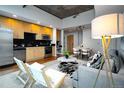 Modern living room featuring a kitchen with light wood cabinetry and stainless steel appliances at 1700 Bassett St # 1119, Denver, CO 80202