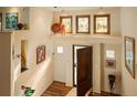 Bright foyer boasts hardwood floors, an open door, transom windows, and decorative wall niches at 8932 Eastridge Rd, Golden, CO 80403