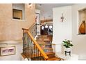 Unique staircase features custom iron railing, hardwood treads, and views into the dining area at 8932 Eastridge Rd, Golden, CO 80403