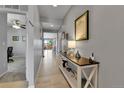 Inviting hallway with light hardwood floors, stylish decor, and a glimpse into the living spaces at 27853 E 8Th Ave, Aurora, CO 80018