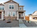Two-story home boasts stone accents, neutral gray siding, and a welcoming front porch, set against a clear blue sky at 259 E 4Th St, Berthoud, CO 80513