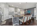 Stylish kitchen with modern white cabinets, a large island, stainless steel appliances, and nice pendant lighting at 1813 W 67Th Ave, Denver, CO 80221