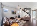 Comfortable living room featuring hardwood floors, a ceiling fan, and a flatscreen TV on the wall at 1813 W 67Th Ave, Denver, CO 80221