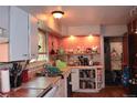 Kitchen with wood cabinets, tile countertops, and open shelves displaying decor and dishware at 2885 Quay St, Wheat Ridge, CO 80033
