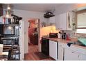 Functional kitchen with white cabinets, appliances, and open doorway to another room at 2885 Quay St, Wheat Ridge, CO 80033