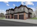 Three-unit townhome building with attached garages and brick accents at 10810 W 63Rd Ave # C, Arvada, CO 80004