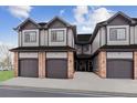 Three-unit townhome building with attached garages and brick accents at 10810 W 63Rd Ave # C, Arvada, CO 80004