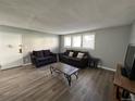 Living room featuring hardwood floors, two couches, a coffee table, and a television at 10211 Ura Ln # 7-108, Thornton, CO 80260