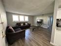 Living room featuring hardwood floors, two couches, a coffee table, and a television at 10211 Ura Ln # 7-108, Thornton, CO 80260