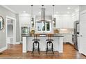 Bright kitchen with white cabinetry, a central island with seating, and stainless steel appliances at 325 S High St, Denver, CO 80209