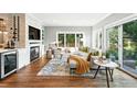 Cozy living room with a stone fireplace, large windows, hardwood floors and modern furnishings at 325 S High St, Denver, CO 80209