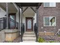 Inviting townhouse entrance featuring a maroon door, black railings, and stone landscaping at 1918 W 165Th Way, Broomfield, CO 80023