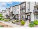 Street view of modern townhomes showcasing gray and white siding with brick accents and landscaped front yards at 1918 W 165Th Way, Broomfield, CO 80023
