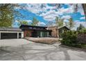 Contemporary home with striking stone chimney and lush green trees at 6260 Lamar St, Arvada, CO 80003