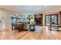 Bright living room featuring hardwood floors, stone fireplace, and views of the backyard and gazebo at 26732 Main St, Conifer, CO 80433